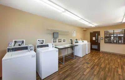 a laundry room with three washers and a counter at Extended Stay America Suites - Akron - Copley - East in Copley