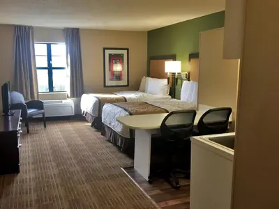 a hotel room with a bed and a table and chairs at Extended Stay America Suites - Akron - Copley - East in Copley