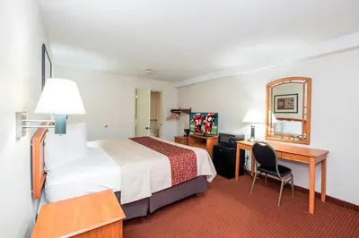 a hotel room with a bed and a desk and a bed sidx sidx sidx sidx at Red Roof Inn Columbus Northeast Westerville in Westerville