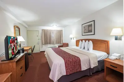 a hotel room with a bed and a flat screen tv at Red Roof Inn Columbus Northeast Westerville in Westerville
