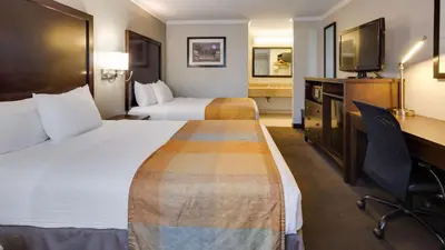 a hotel room with two beds and a desk at Best Western Clermont in Cincinnati