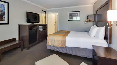 a hotel room with a bed and a flat screen tv at Best Western Clermont in Cincinnati