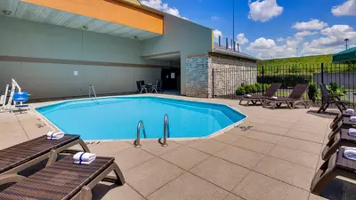 a swimming pool with two chairs and a patio at Best Western Clermont in Cincinnati