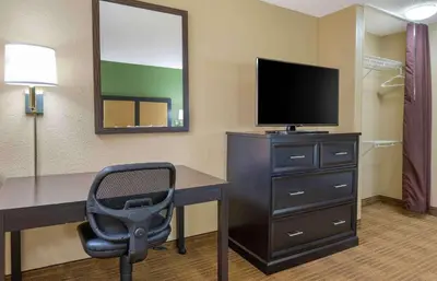 a room with a desk with a television and a chair at Extended Stay America Select Suites - Columbus - Worthington in Worthington