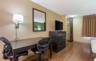 a room with a desk with two chairs and a television at Extended Stay America Select Suites - Columbus - Worthington in Worthington