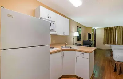 a kitchen with a white refrigerator and a living room at Extended Stay America Select Suites - Columbus - Worthington in Worthington