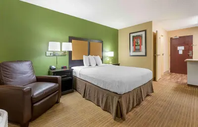 a hotel room with a bed and a chair at Extended Stay America Select Suites - Columbus - Worthington in Worthington