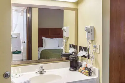 a bathroom with a sink and a large mirror at Quality Inn Athens in Athens