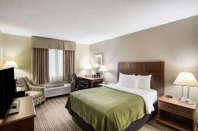 a hotel room with a bed and a chair at Quality Inn Athens in Athens