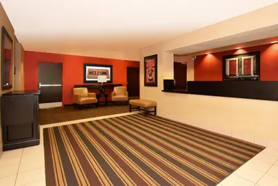 a lobby with red walls and a waiting room at Extended Stay America Suites - Cincinnati - Florence - Turfway Rd in Florence