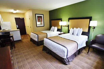 a hotel room with two beds and a chair at Extended Stay America Suites - Cincinnati - Florence - Turfway Rd in Florence