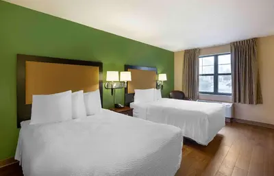 a hotel room with two beds and a green wall at Extended Stay America Suites - Cleveland - Brooklyn in Brooklyn