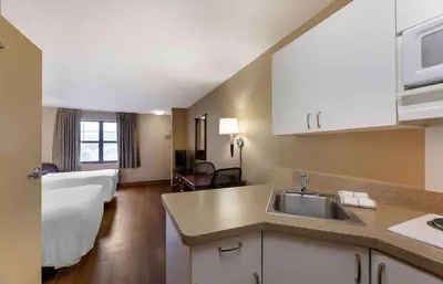 a kitchen with a sink and a living room at Extended Stay America Suites - Cleveland - Brooklyn in Brooklyn