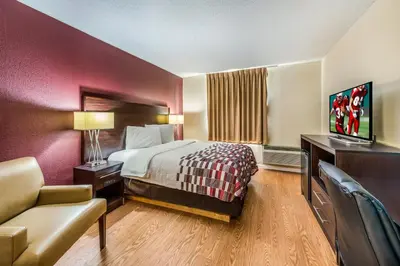 a hotel room with a bed and a television at Red Roof Inn & Suites Wapakoneta in Wapakoneta
