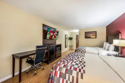 a hotel room with a desk and a bed and a desk at Red Roof Inn & Suites Wapakoneta in Wapakoneta
