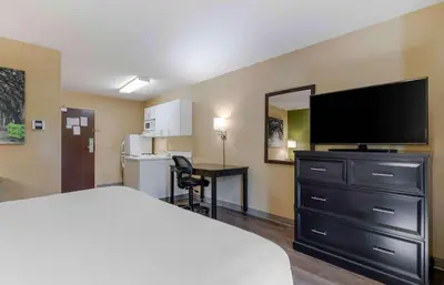 a hotel room with a bed and a flat screen tv at Extended Stay America Suites - Columbus - NE - I-270 in Gahanna