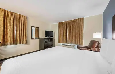 a hotel room with a large bed and a television at Extended Stay America Suites - Dayton - North in Dayton