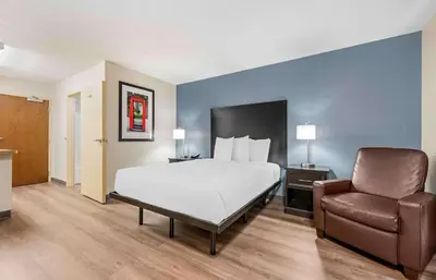 a hotel room with a bed and a chair at Extended Stay America Suites - Dayton - North in Dayton