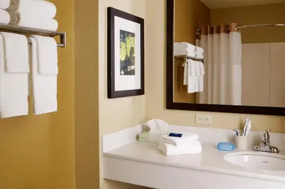 a bathroom with a sink and a mirror and towels at Extended Stay America Suites - Cincinnati - Covington in Covington