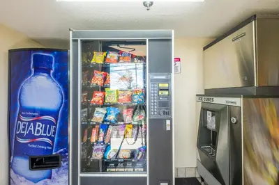 a refrigerator with a bottle of water and snacks at Red Roof Inn Cincinnati - Sharonville in Sharonville
