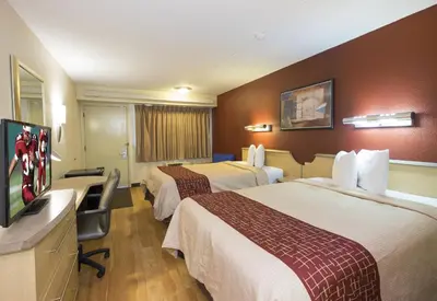 a hotel room with two beds and a flat screen tv at Red Roof Inn Cincinnati - Sharonville in Sharonville