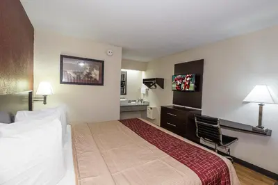 a hotel room with a bed and a desk at Red Roof Inn Columbus East- Reynoldsburg in Brice