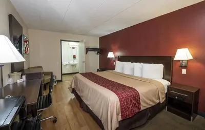 a hotel room with a bed and a desk at Red Roof Inn Columbus East- Reynoldsburg in Brice