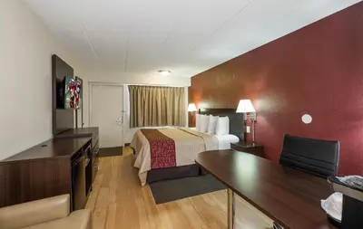 a hotel room with a bed and a desk at Red Roof Inn Columbus East- Reynoldsburg in Brice