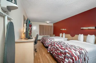 a hotel room with two beds and a flat screen tv at Red Roof Inn Cleveland - Mentor/ Willoughby in Willoughby