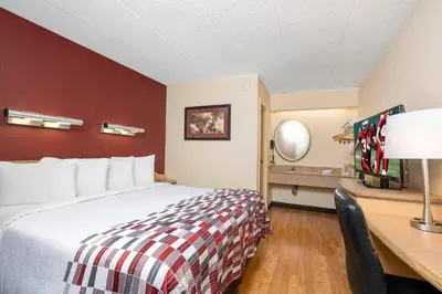 a hotel room with a bed and a desk at Red Roof Inn Cleveland - Mentor/ Willoughby in Willoughby
