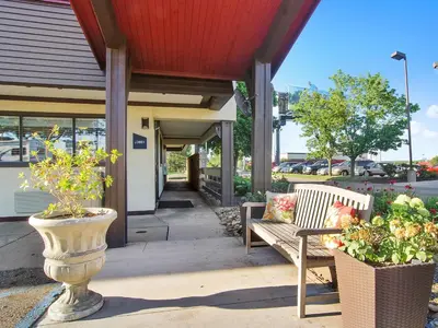two benches sitting outside of a building with flowers at Red Roof Inn Canton in Canton