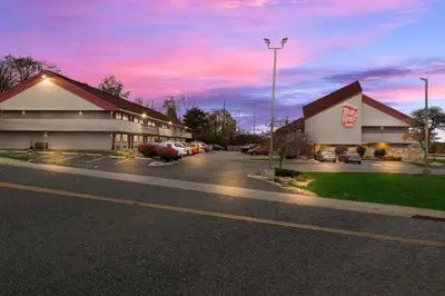 a building with a parking lot with cars parked outside at Red Roof Inn Cleveland - Independence in Independence
