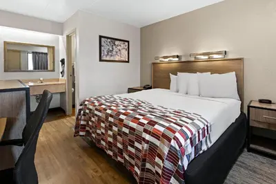 a hotel room with a bed and a bathroom at Red Roof Inn Cleveland - Independence in Independence