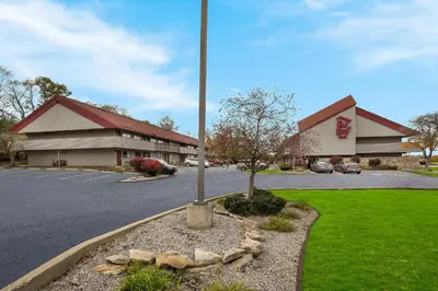 a parking lot with a flag pole in front of a building at Red Roof Inn Cleveland - Independence in Independence