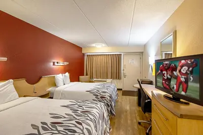 a hotel room with two beds and a flat screen tv at Red Roof Inn Charleston - Kanawha City, WV in Charleston