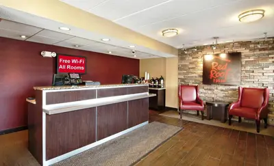 a bar with two red chairs and a restaurant at Red Roof Inn Charleston - Kanawha City, WV in Charleston