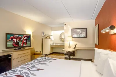 a hotel room with a bed and a flat screen tv at Red Roof Inn Charleston - Kanawha City, WV in Charleston