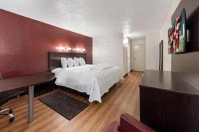 a hotel room with a bed and a desk at Red Roof Inn PLUS+ Columbus - Worthington in Columbus