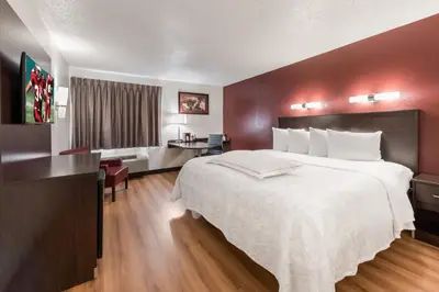 a hotel room with a large bed and a desk at Red Roof Inn PLUS+ Columbus - Worthington in Columbus