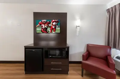 a room with a couch and a tv and a chair at Red Roof Inn PLUS+ Columbus - Worthington in Columbus