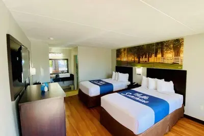 a hotel room with two beds and a flat screen tv at Days Inn by Wyndham Maysville Kentucky in Maysville