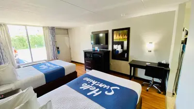 a hotel room with two beds and a desk at Days Inn by Wyndham Maysville Kentucky in Maysville