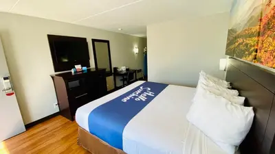 a hotel room with a bed and a television at Days Inn by Wyndham Maysville Kentucky in Maysville