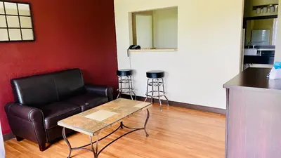 a living room with a leather couch and a table at Days Inn by Wyndham Maysville Kentucky in Maysville