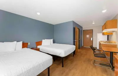a hotel room with two beds and a desk at Extended Stay America Select Suites - Cleveland - Avon in Avon