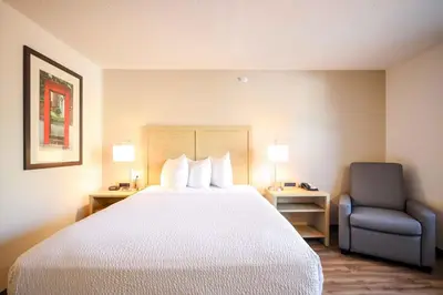 a hotel room with a bed and a chair at Extended Stay America Suites - Cleveland - Beachwood - Orange Place - South in Orange
