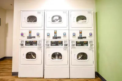 four washers and dryers are in a room at Extended Stay America Suites - Cleveland - Beachwood - Orange Place - South in Orange