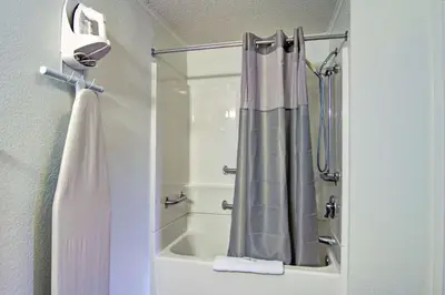 a bathroom with a shower curtain and a bath tub at Suburban Studios Mentor - Cleveland Northeast in Mentor