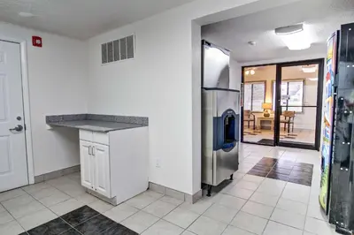 a kitchen with a counter and a refrigerator at Suburban Studios Mentor - Cleveland Northeast in Mentor