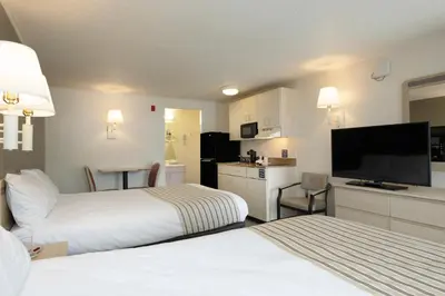 a hotel room with two beds and a flat screen tv at Suburban Studios Mentor - Cleveland Northeast in Mentor